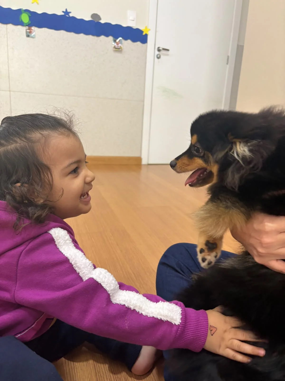 Criança abraçando um cachorro durante o projeto sobre animais